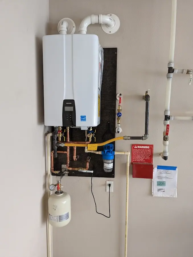 Professional plumber installing copper piping in a Barton home